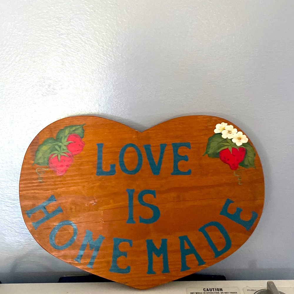 Heart shaped love is homemade wood sign.